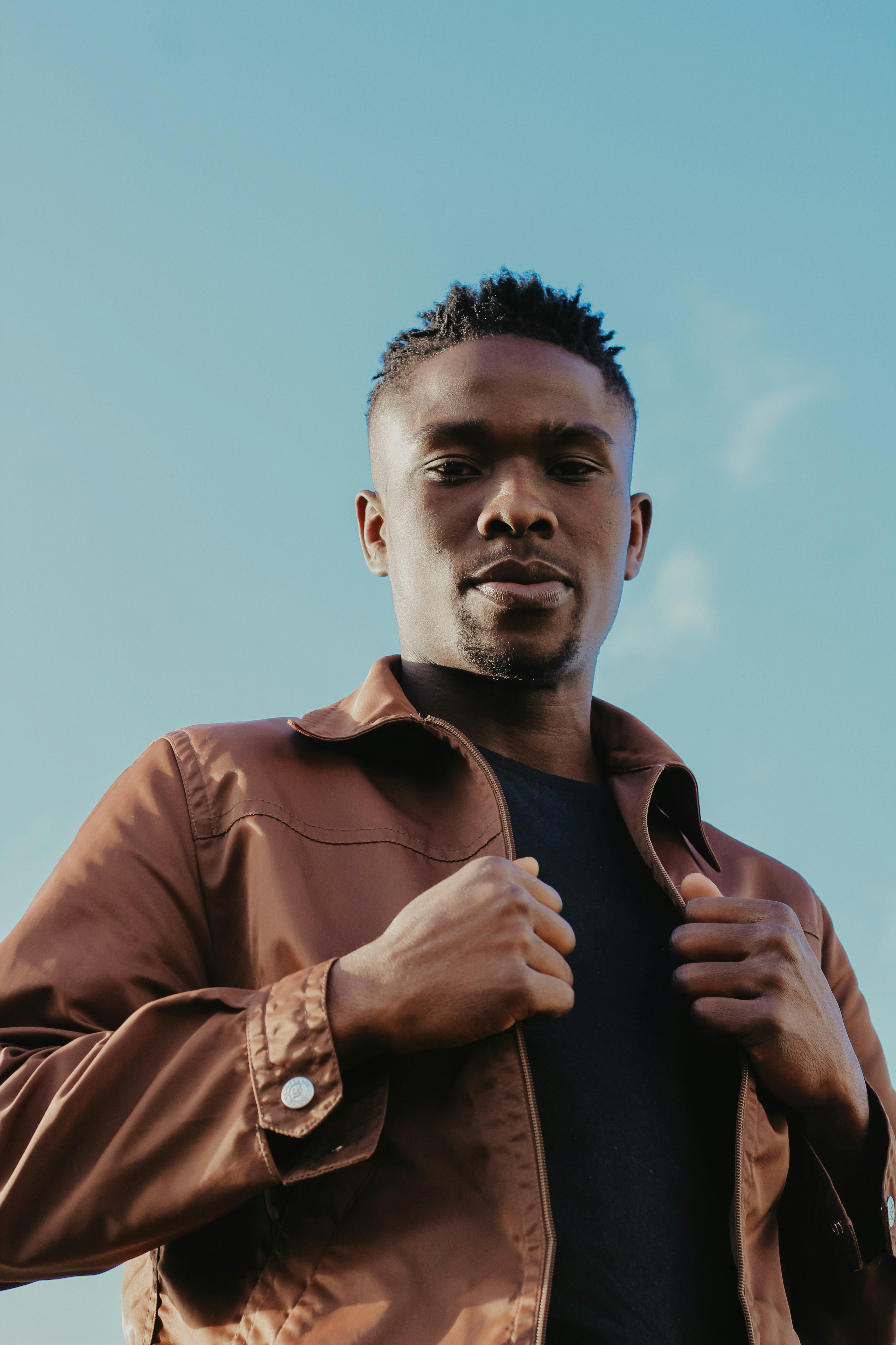 a man wearing a brown jacket and a black shirt