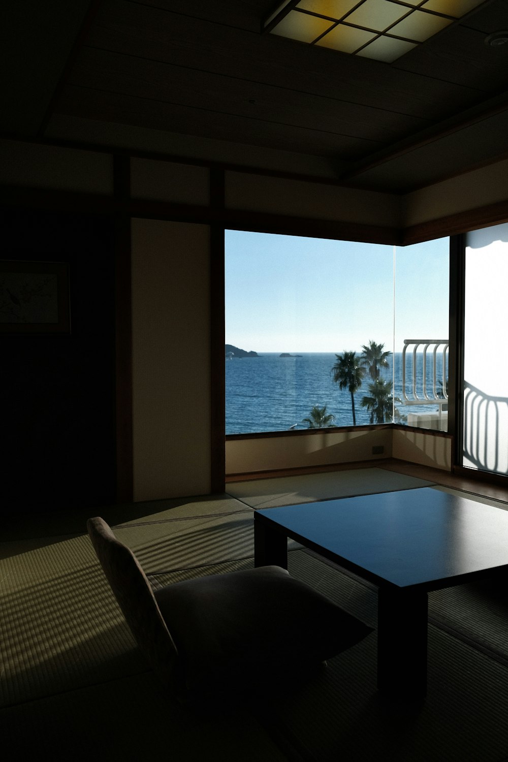 a room with a table and a view of the ocean