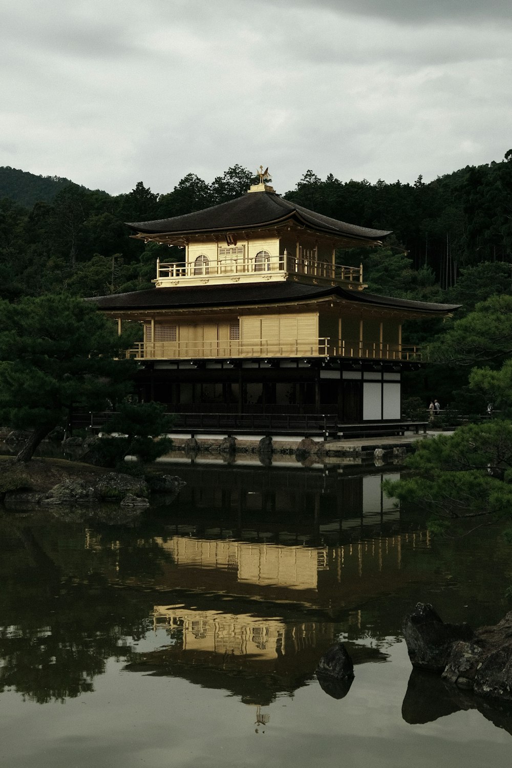 a building sitting on top of a lake next to a forest