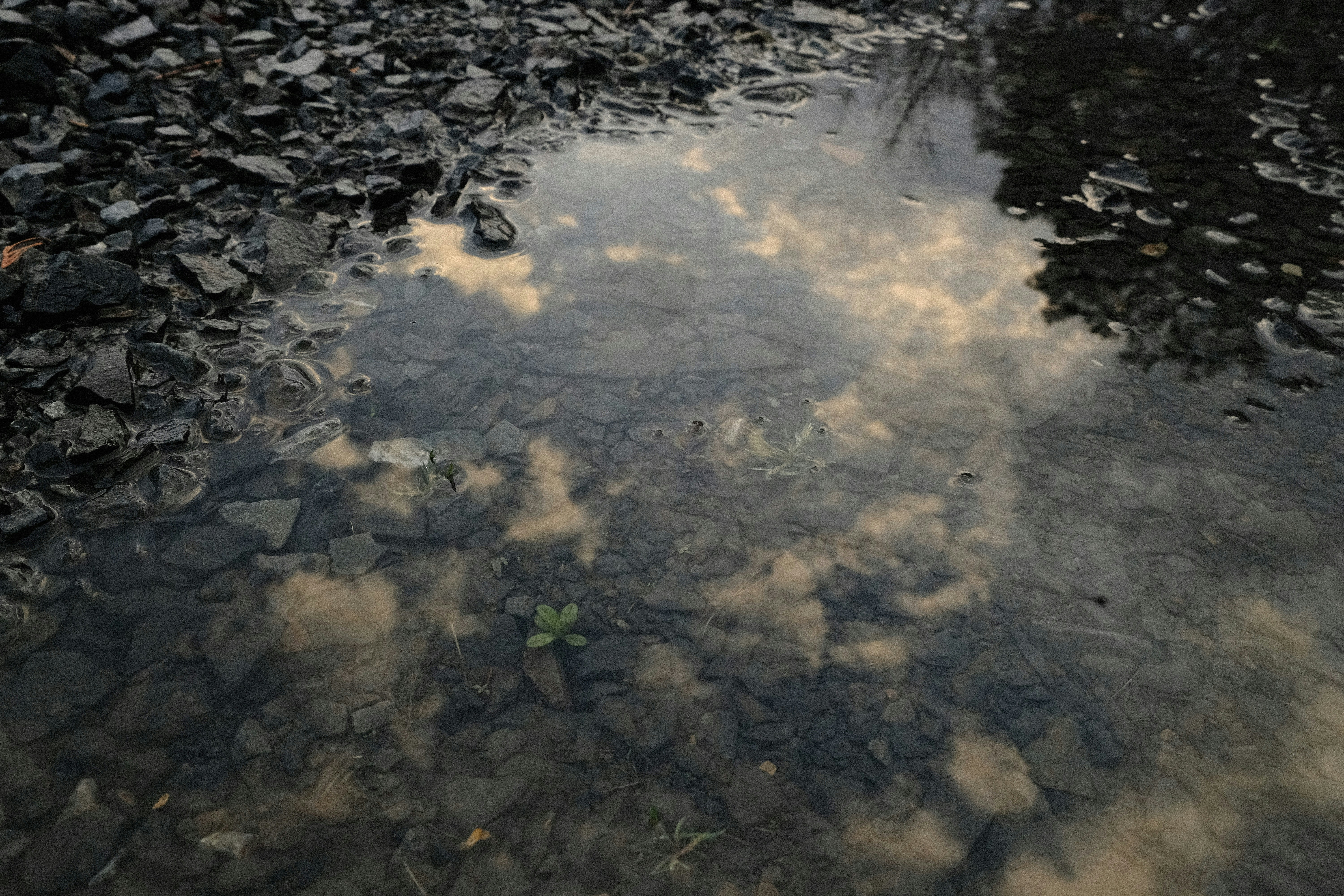 a body of water with rocks and clouds in it