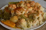 a white plate topped with cauliflower and broccoli