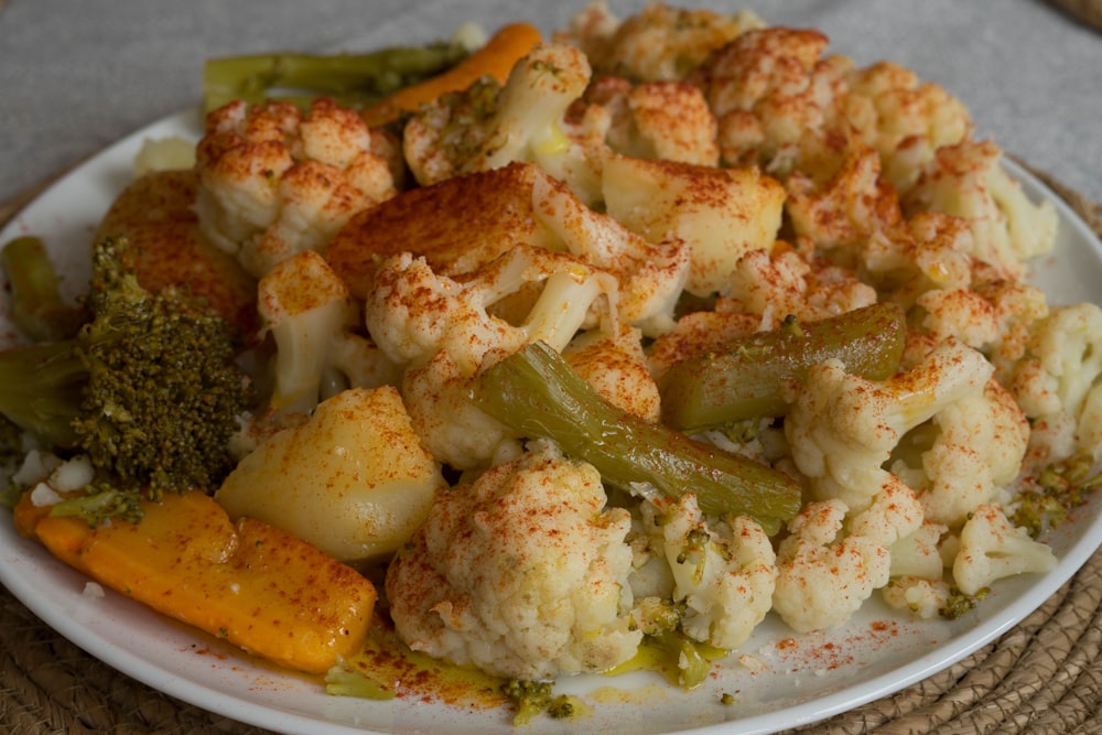 a white plate topped with cauliflower and broccoli