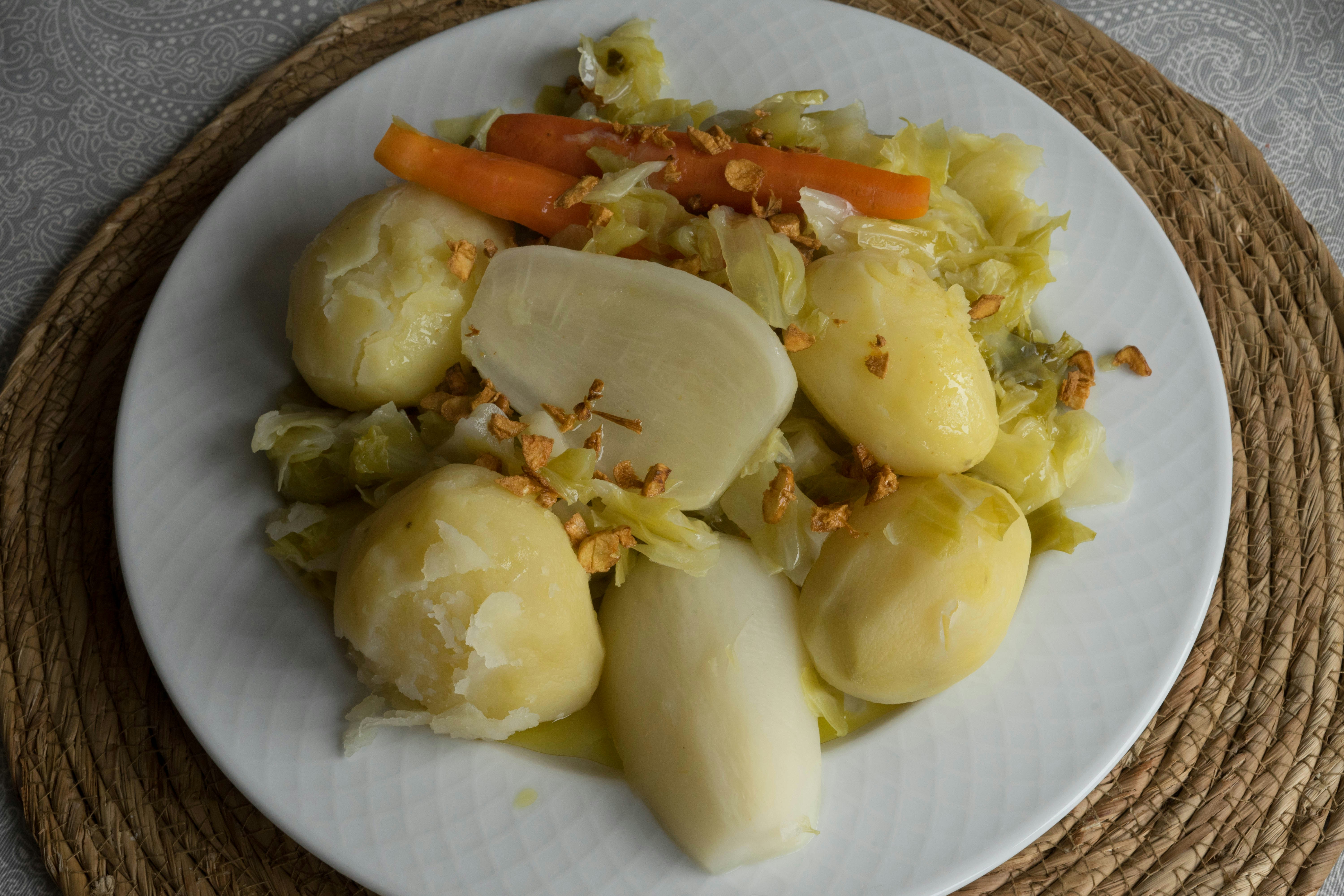 a white plate topped with potatoes and carrots