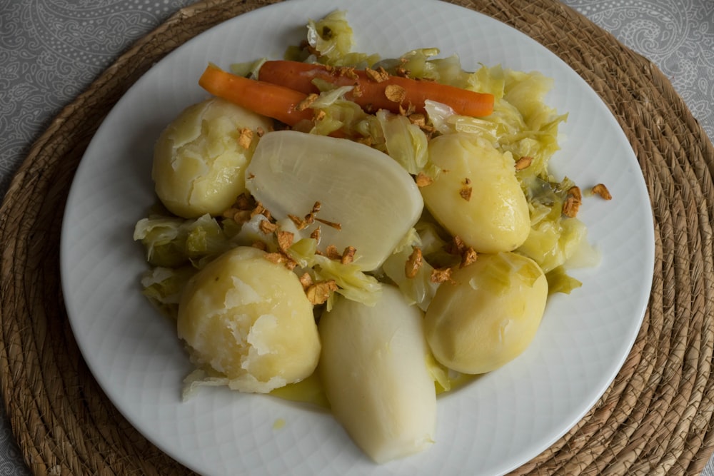 a white plate topped with potatoes and carrots