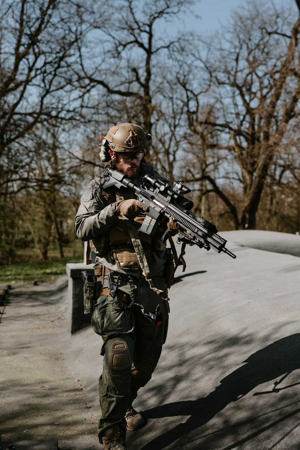 a man with a rifle walking down a path