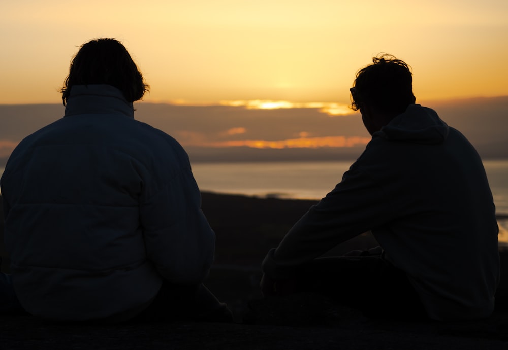 a couple of men sitting next to each other