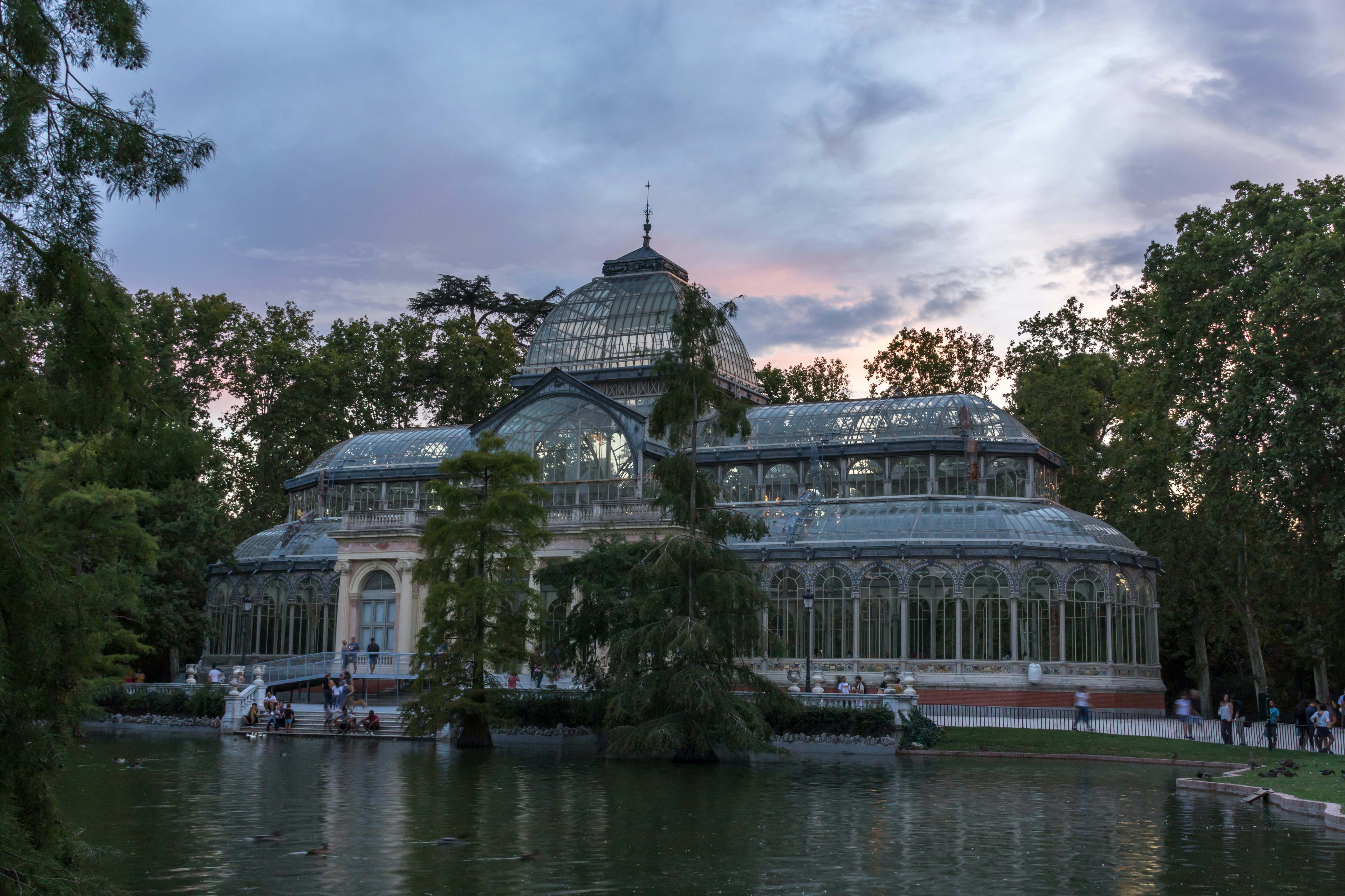 un grand bâtiment avec une verrière à côté d’un plan d’eau
