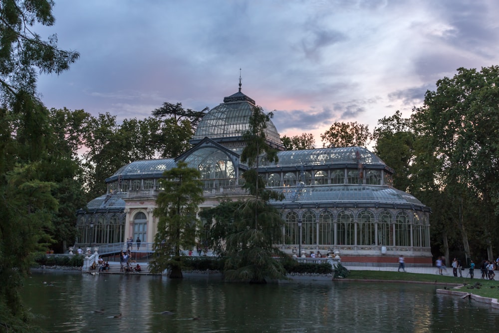 a large building with a glass roof next to a body of water