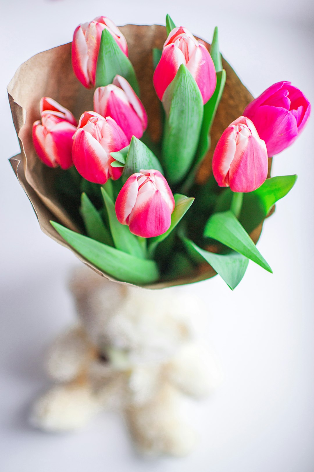 Beautiful fresh morning pink bouquet of tulips on the window. Fragrant smell of fresh spring tulips in a paper wrapper