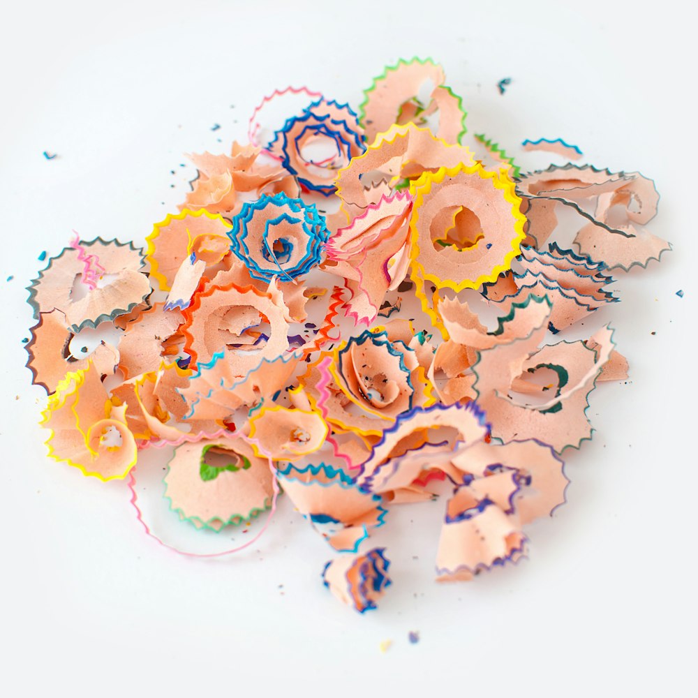 a pile of colorful paper flowers sitting on top of a white table