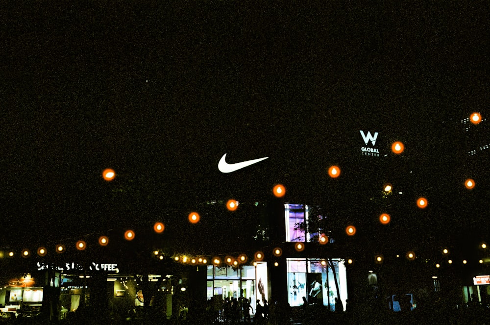 a group of people standing outside of a building at night