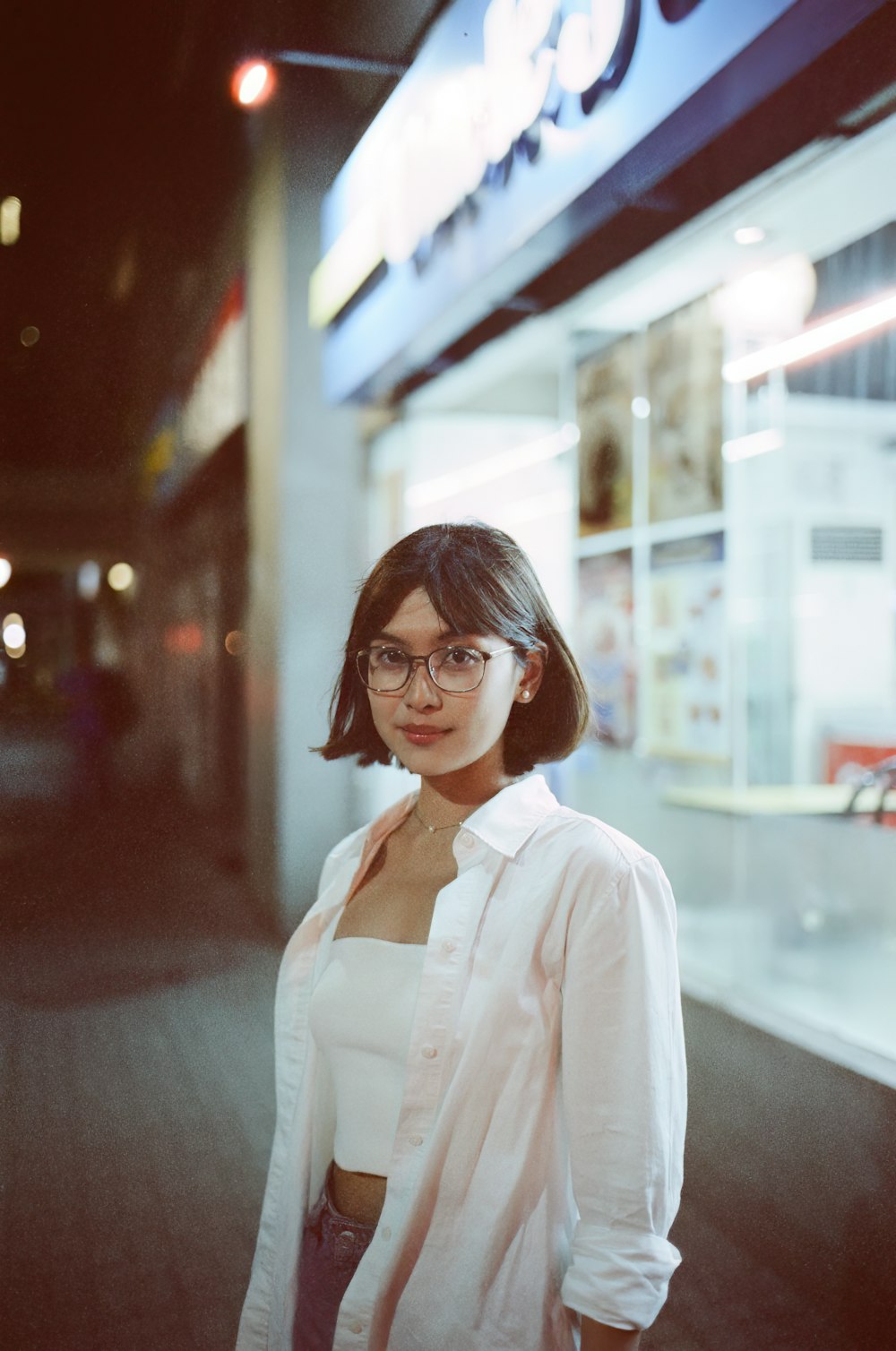 a woman standing in front of a building at night