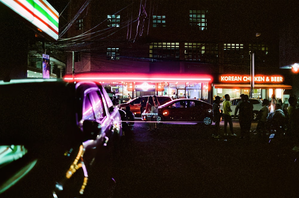 a group of people standing outside of a building at night