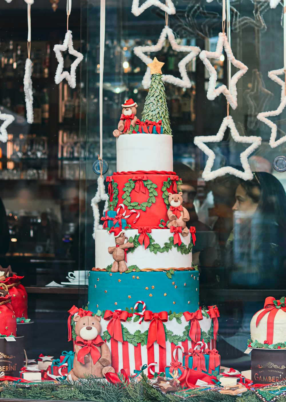 a multi - tiered christmas cake is displayed in a window