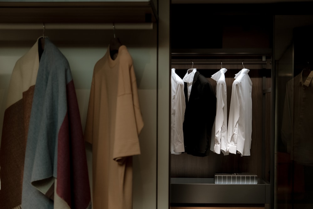Un armario con ropa colgada en una barandilla