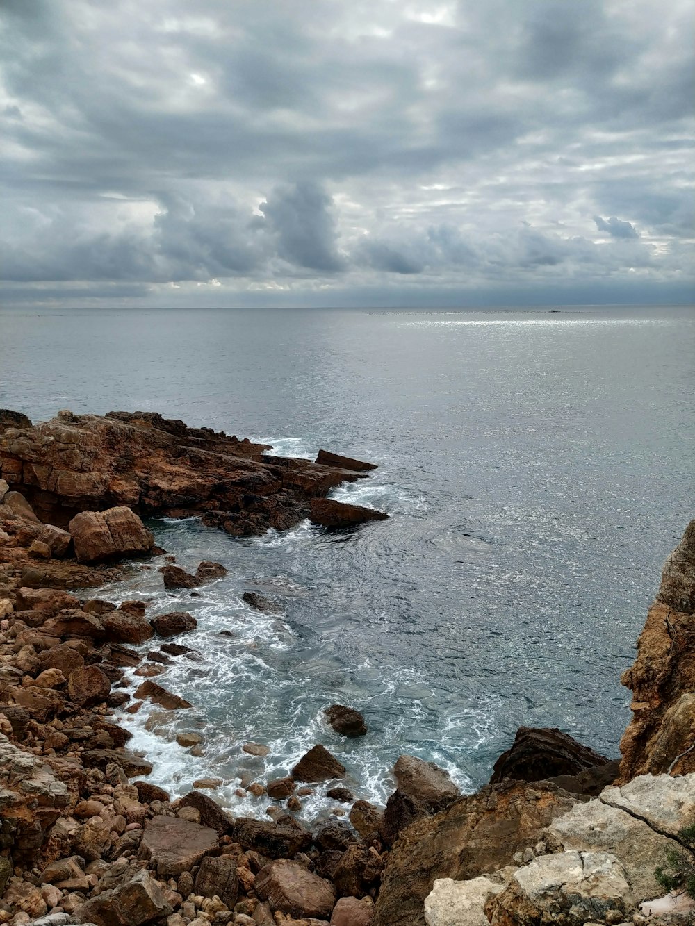 a view of the ocean from a rocky cliff