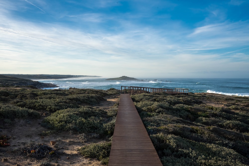 a wooden walkway leading to the beach with a view of the ocean