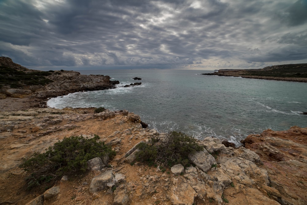 a body of water sitting on top of a rocky cliff