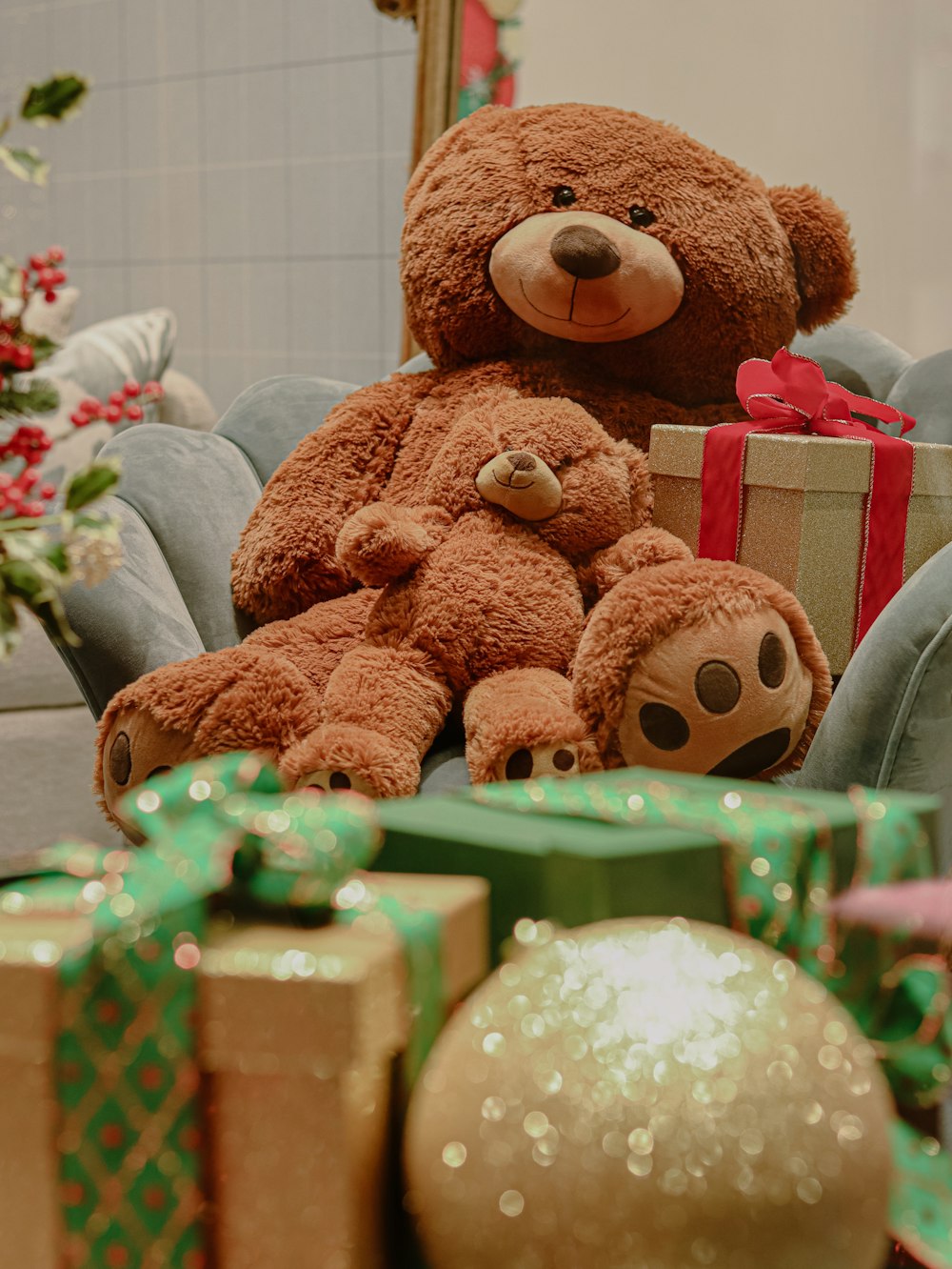 a brown teddy bear sitting on a chair with presents