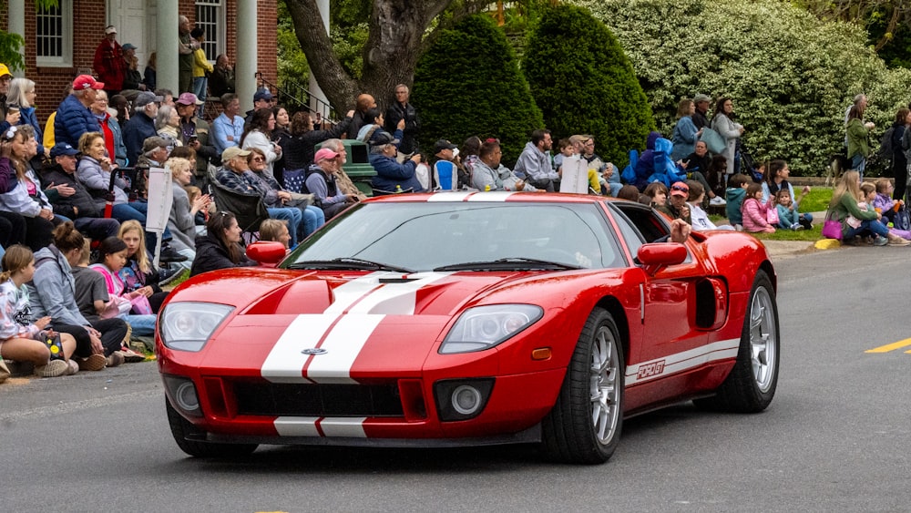 a red and white sports car driving down a street