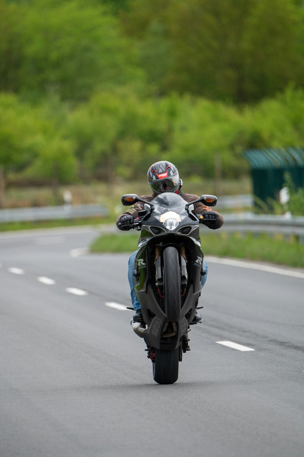 Ein Mann fährt mit einem Motorrad eine kurvige Straße hinunter