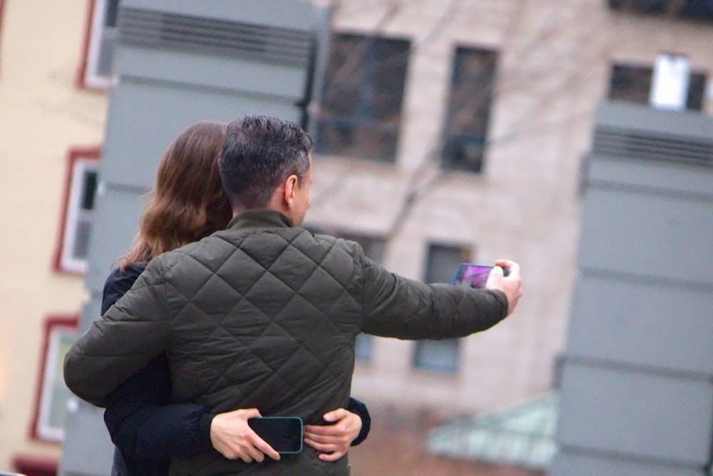 a man and a woman taking a picture with a cell phone