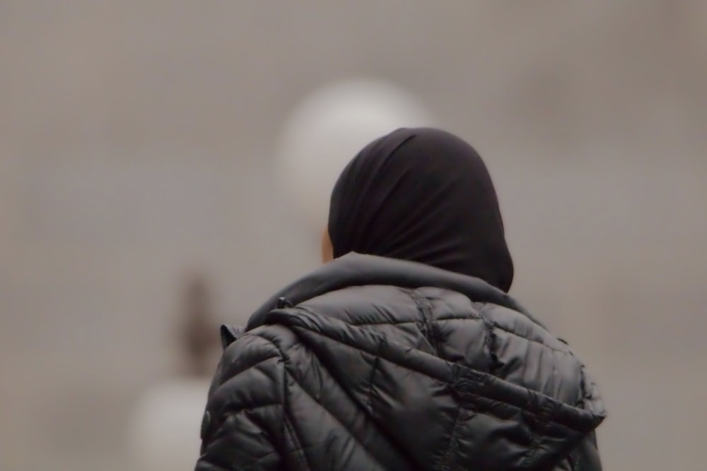 un'immagine sfocata di una persona con una giacca nera