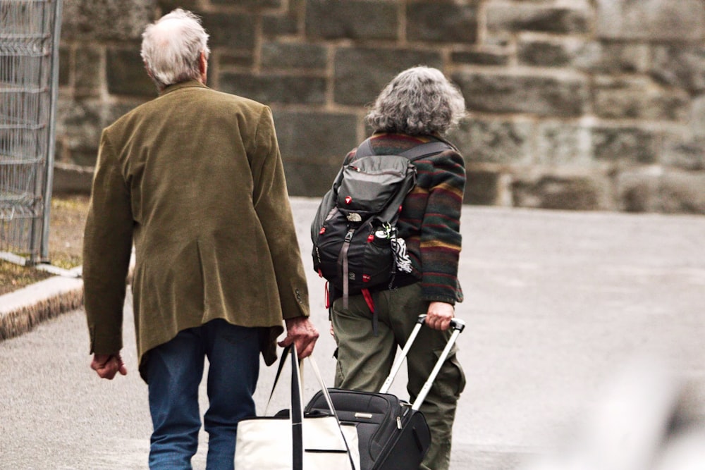 a man and a woman walking down the street with luggage