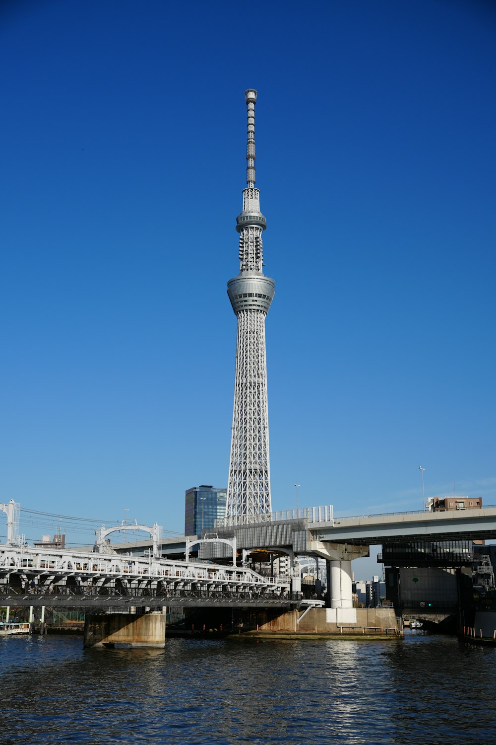 a very tall tower towering over a city next to a bridge