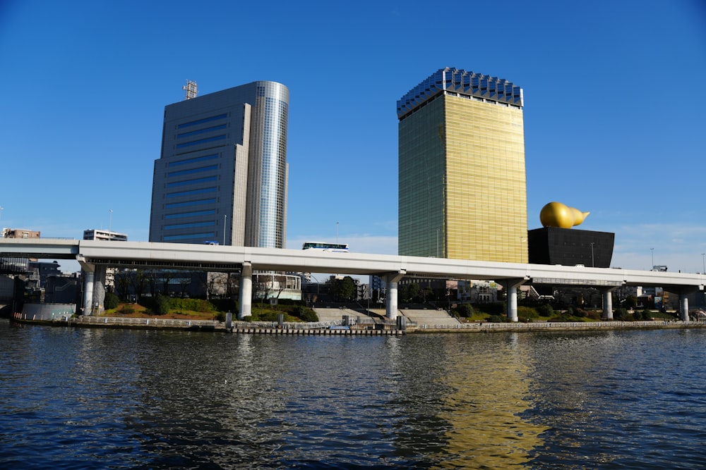 a bridge over a body of water with buildings in the background