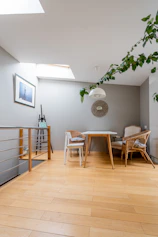 a room with a wooden floor and a table and chairs