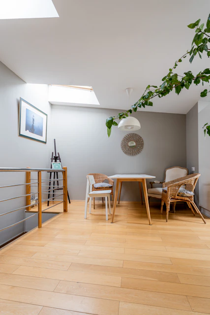 a room with a wooden floor and a table and chairs