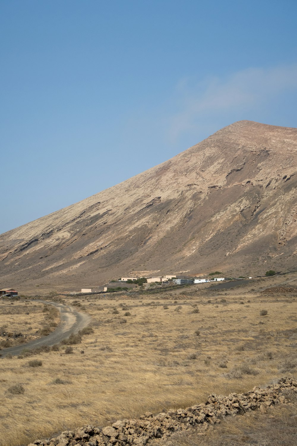 a dirt road in front of a mountain