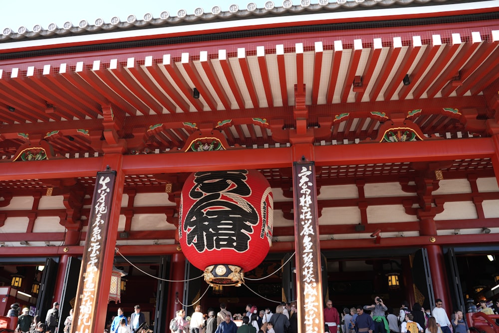 a group of people standing in front of a red building