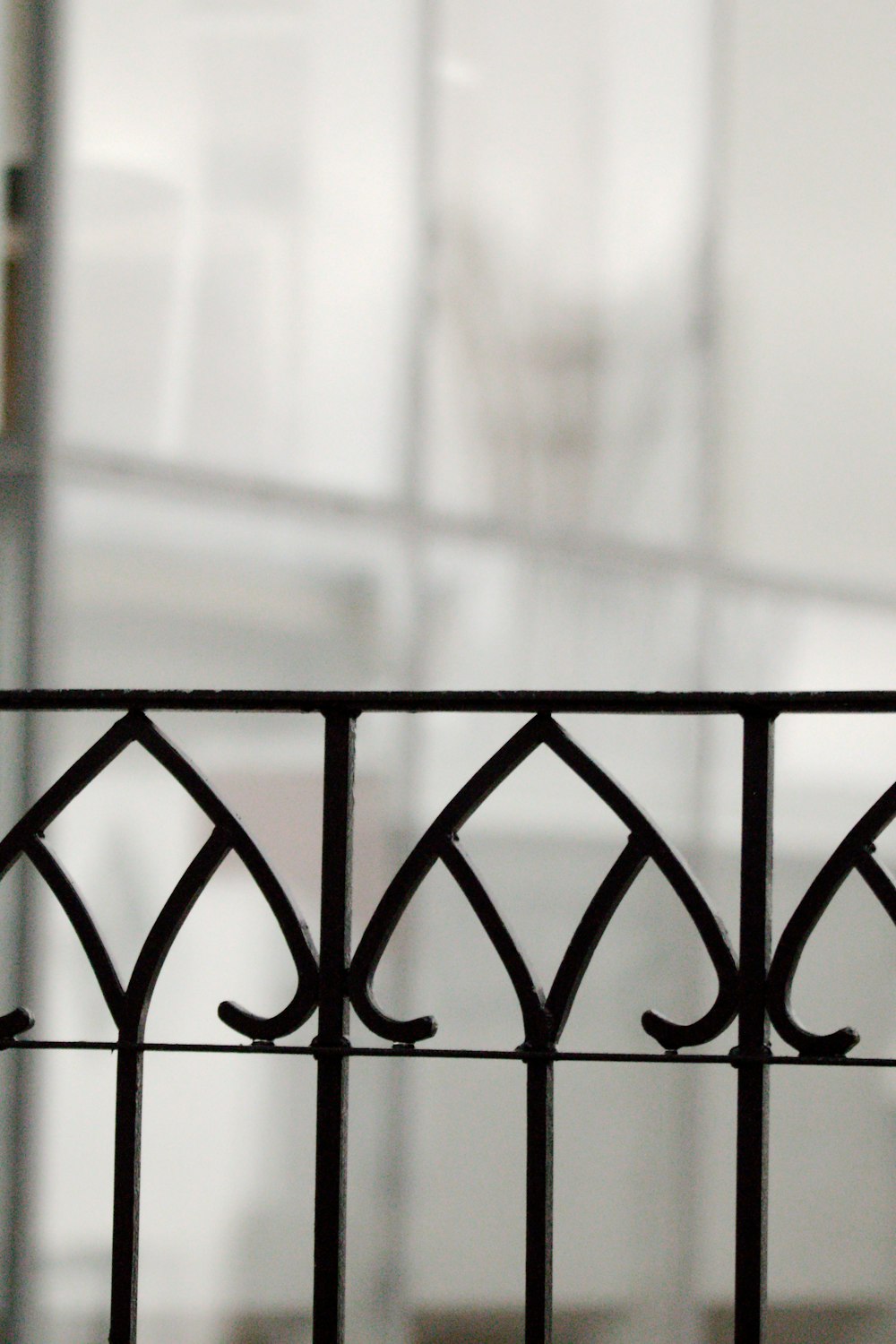 a close up of a metal fence with a building in the background