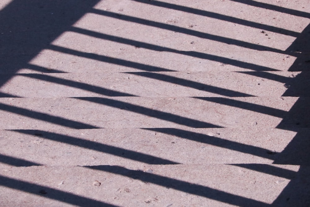 a shadow of a person walking on a sidewalk