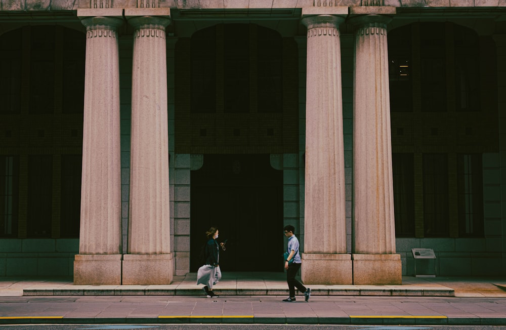 a couple of people that are standing in front of a building