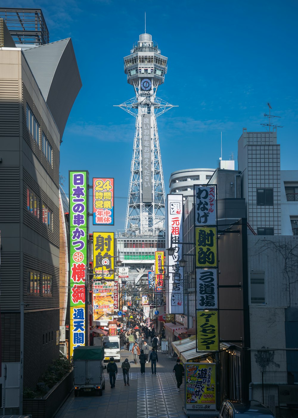 a group of people walking down a street next to tall buildings