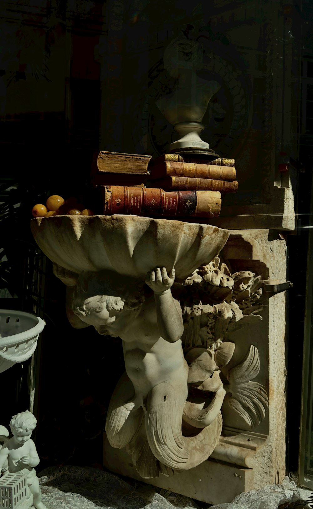 a statue of a boy with a book on his head