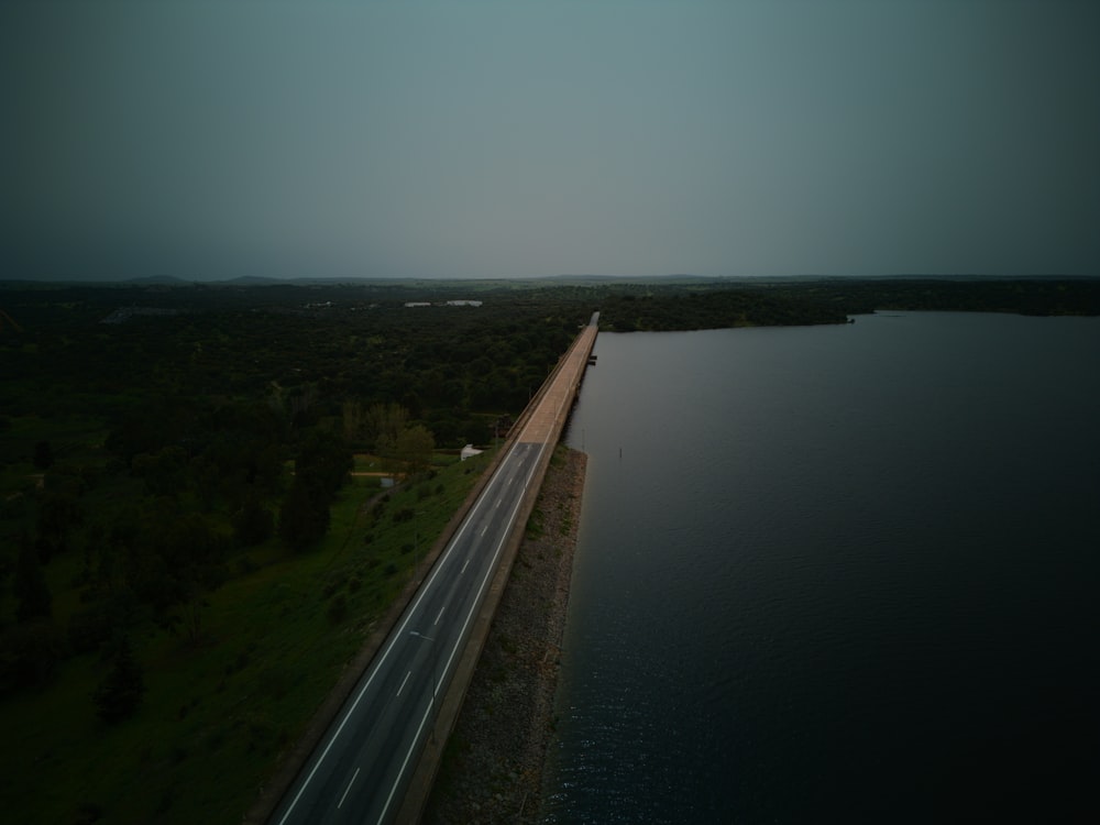 an aerial view of a highway next to a body of water