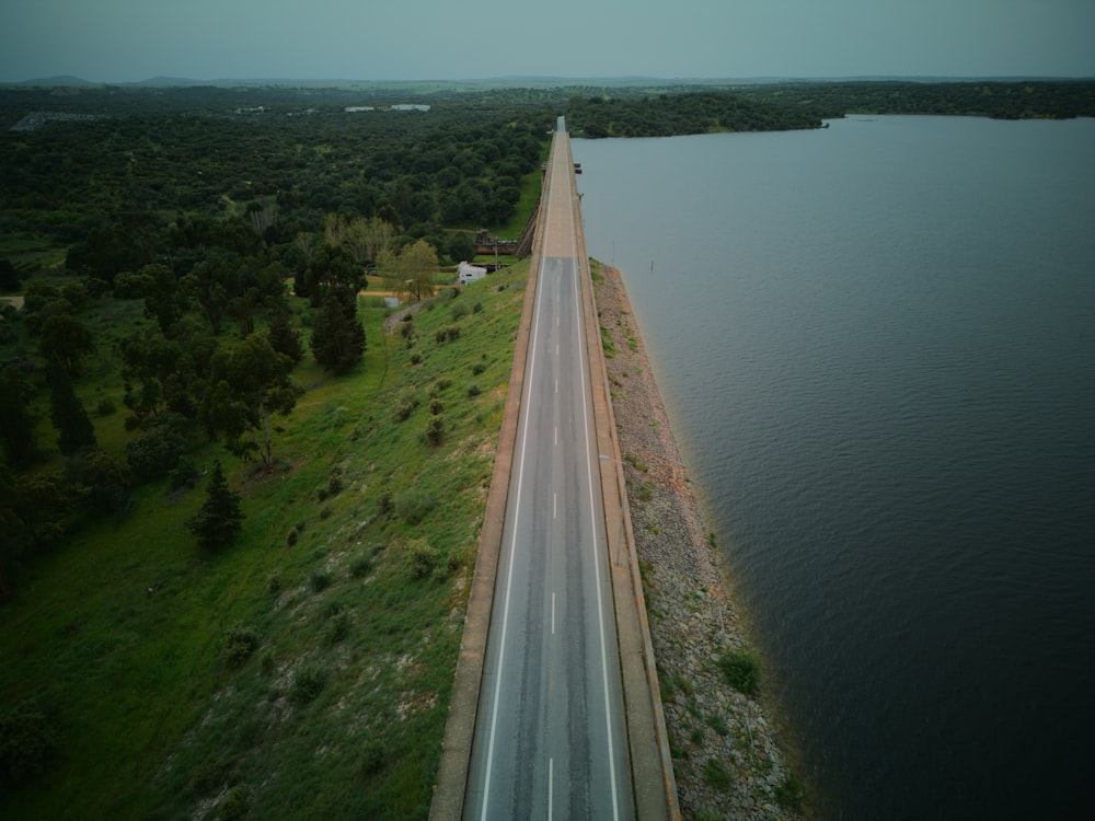 an aerial view of a highway next to a body of water
