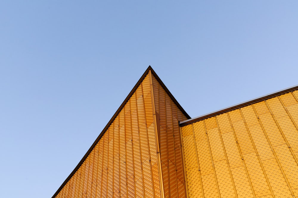 a tall yellow building with a clock on it's side