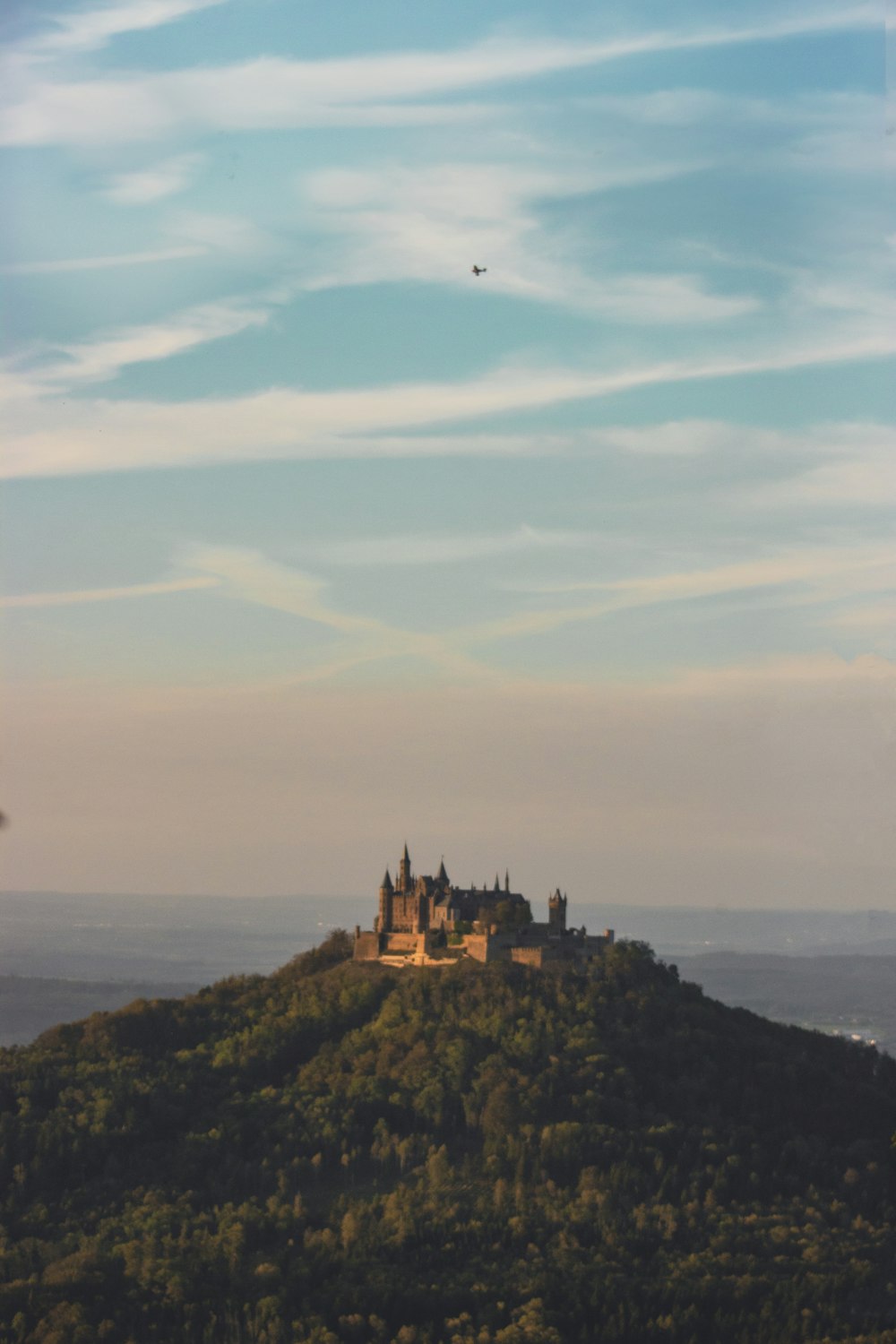 a castle sitting on top of a lush green hillside