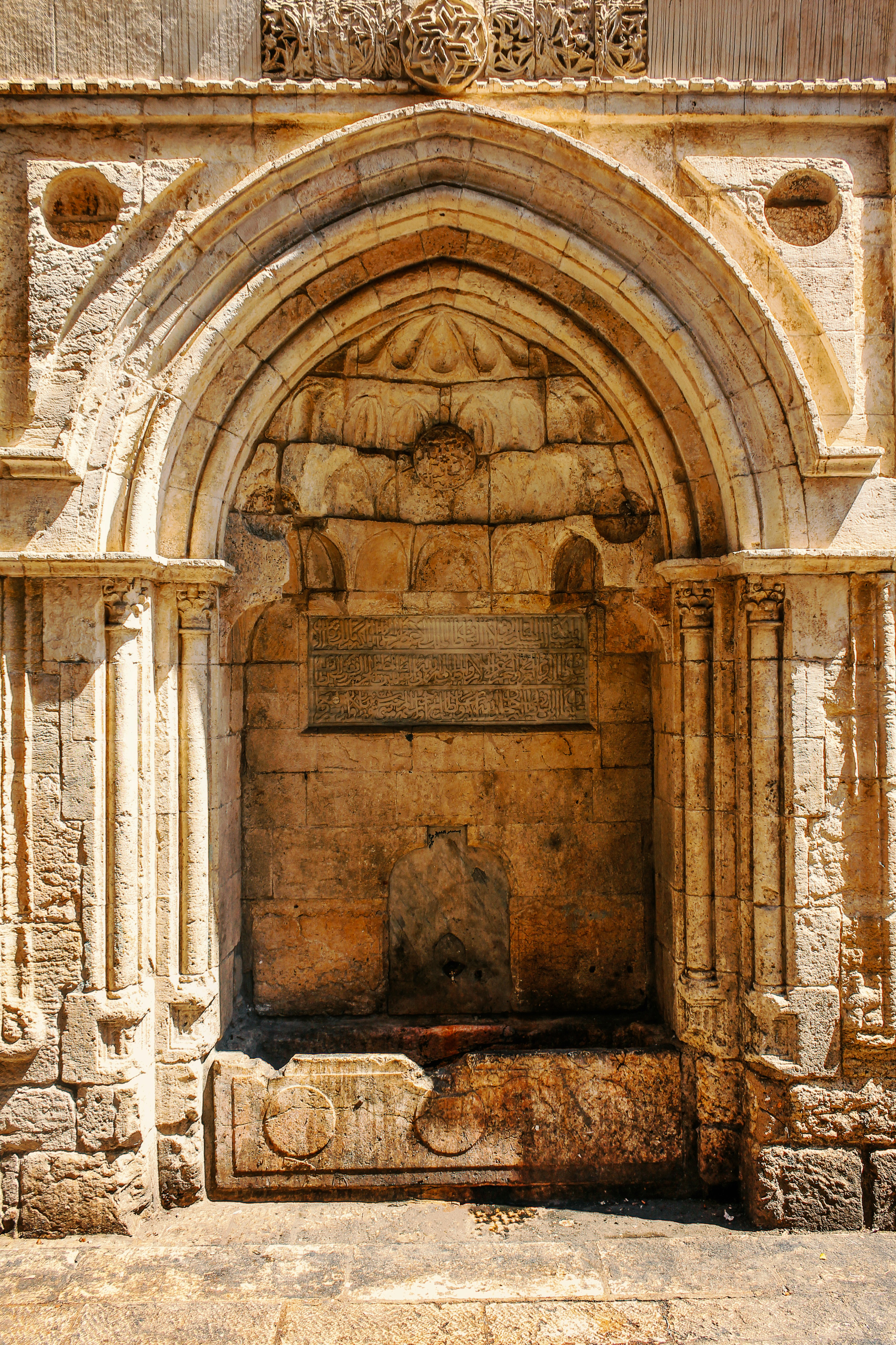 an old stone building with a fountain in the middle of it