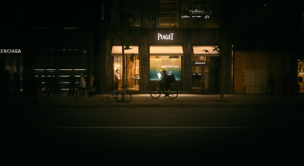 a man riding a bike down a street at night