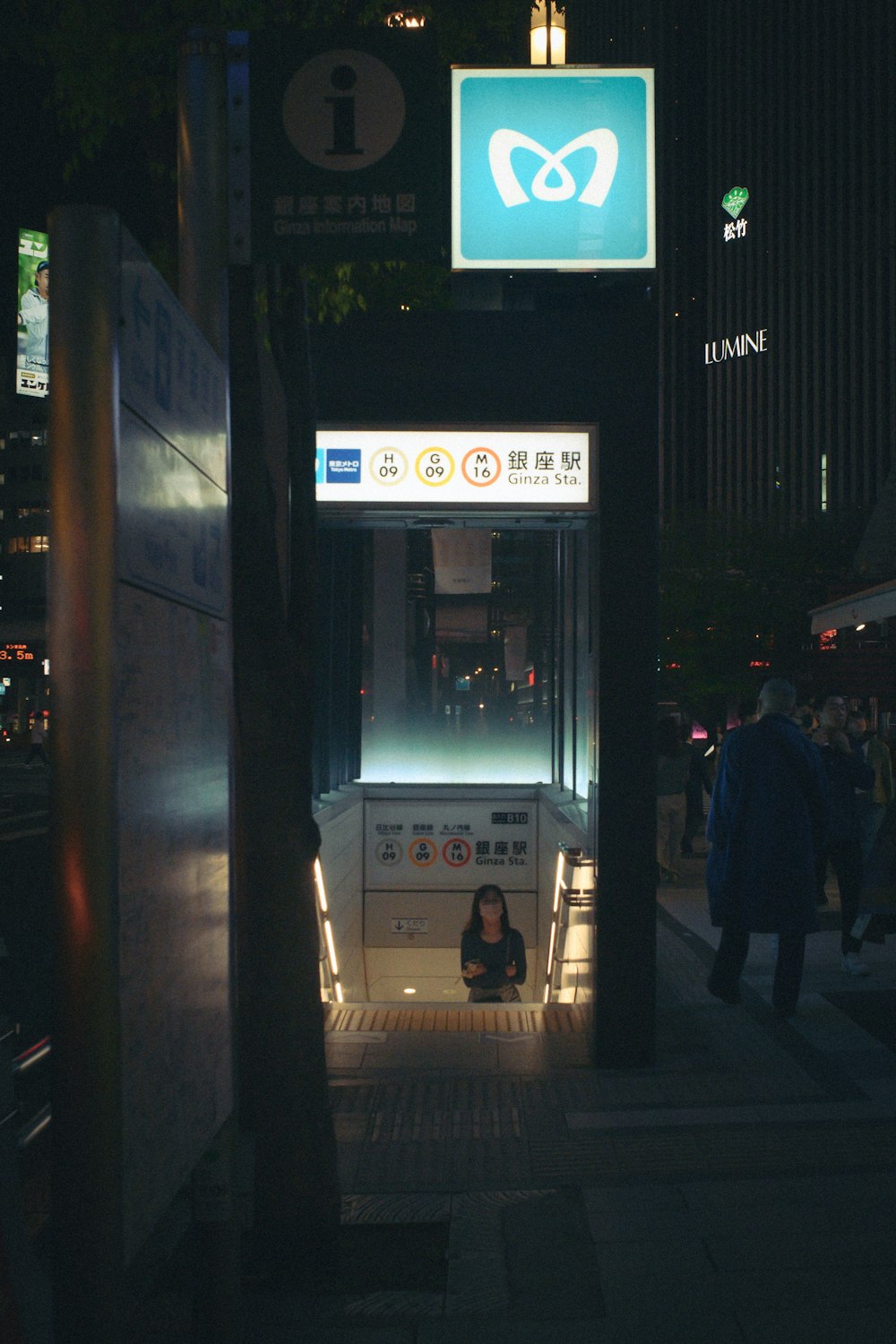 uma mulher sentada em um ponto de ônibus à noite