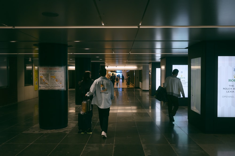 a couple of people that are walking down a hallway