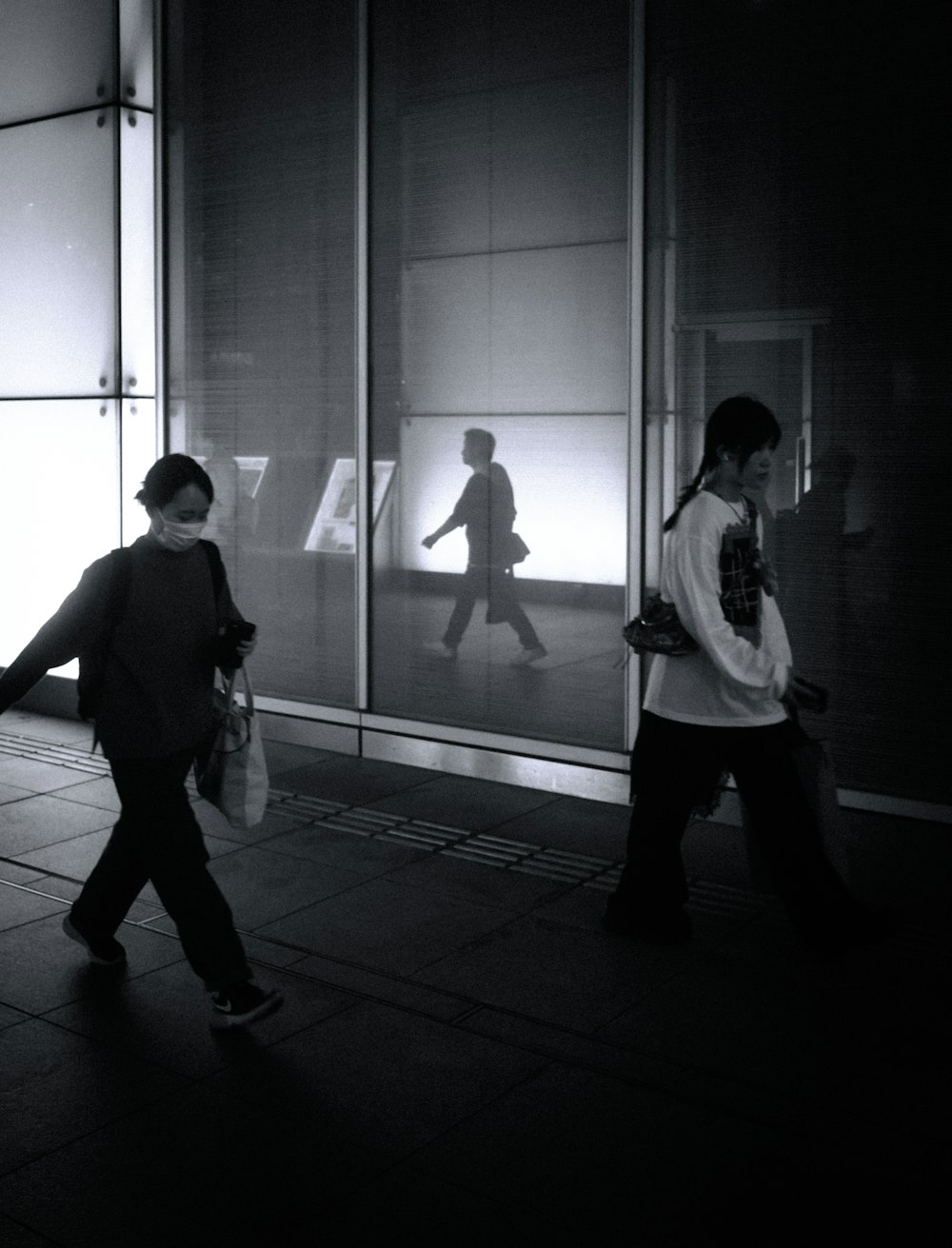 a couple of people walking past a tall building