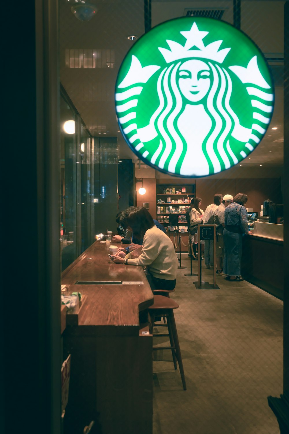 Uma placa da Starbucks pendurada na lateral de um prédio