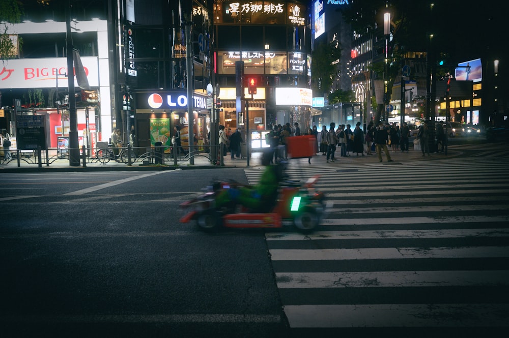 a person riding a motorcycle down a street at night